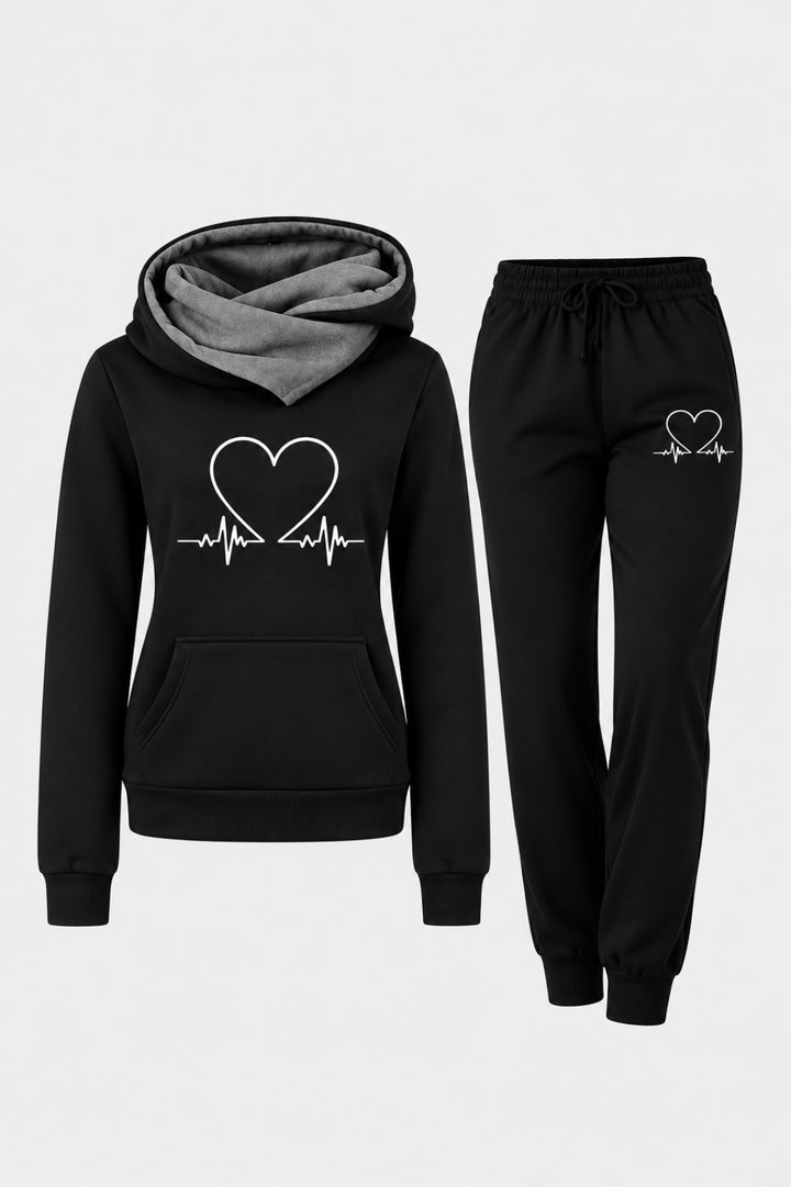 Svart damhoodie med gråt foder i huvan och vitt hjärtmönster, i kombination med svarta joggingbyxor