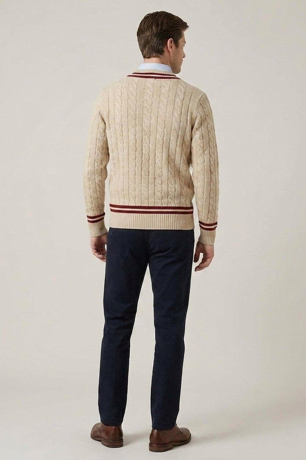 Beige kabelstickad herrtröja med vinröda detaljer, sedd bakifrån