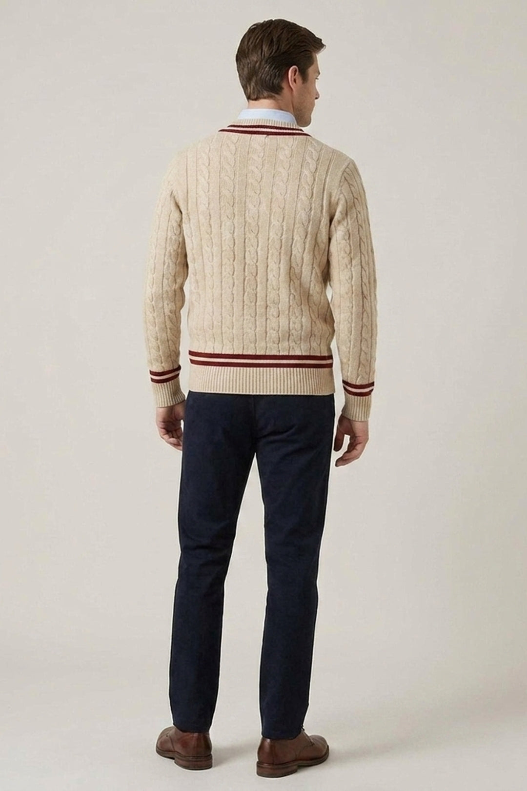 Beige kabelstickad herrtröja med vinröda detaljer, sedd bakifrån