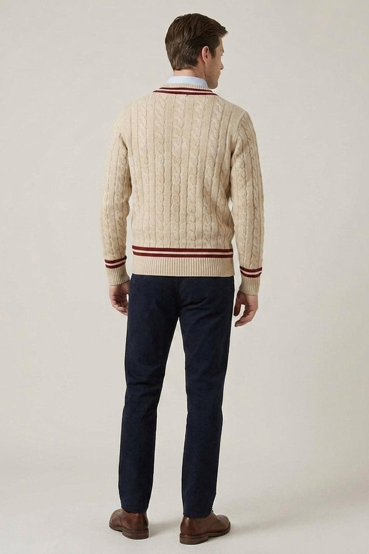 Beige kabelstickad herrtröja med vinröda detaljer, sedd bakifrån